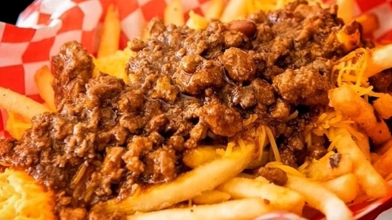Cheese-covered French fries smothered in beef chili, served in a checkered napkin