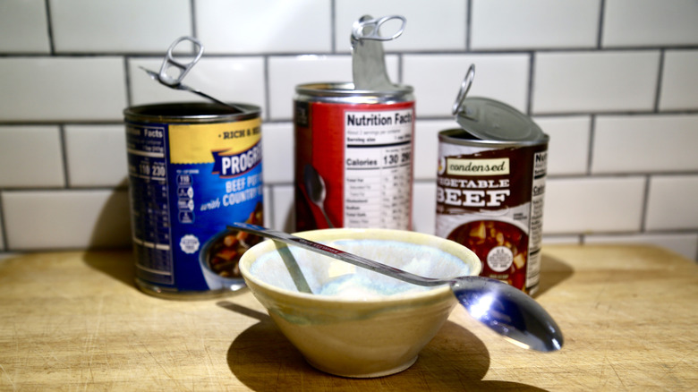 Opened cans and empty bowl with spoon