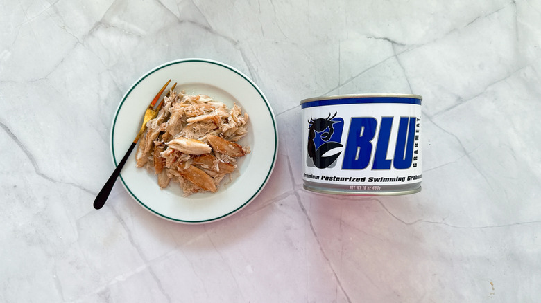 Crabmeat on a plate next to a can of Blu crab meat