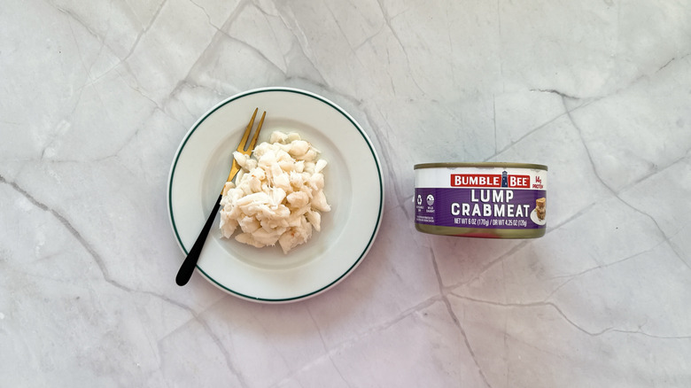 Crabmeat on a plate net to a can of Bumble Bee crab meat