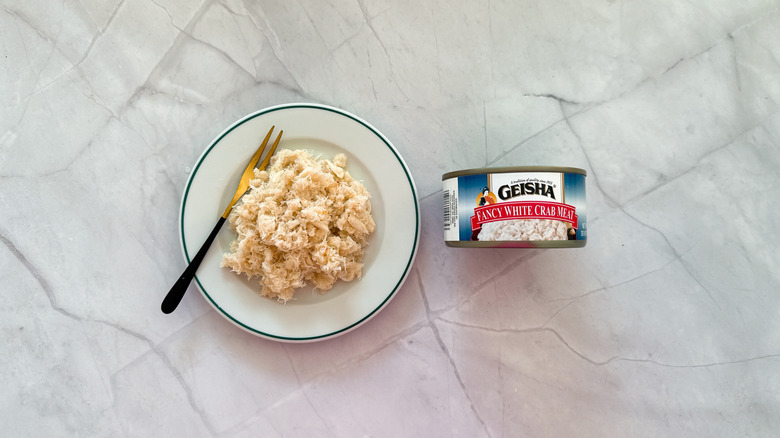Crabmeat on a plate next to a can of Geisha crab meat.