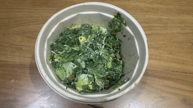 Chopt's kale Caesar salad on a wooden surface