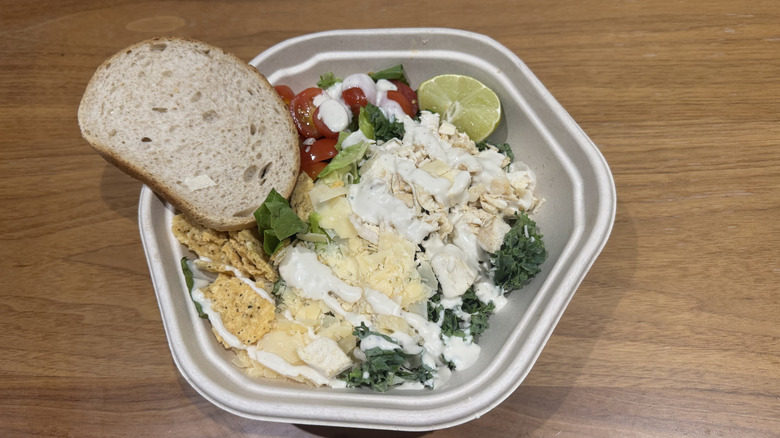 Sweetgreen's kale Caesar salad on a wooden surface