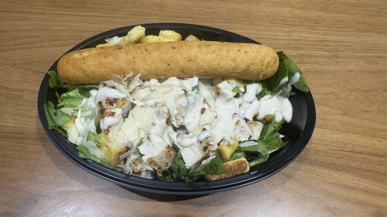 Applebee's grilled chicken Caesar salad on a wooden surface.