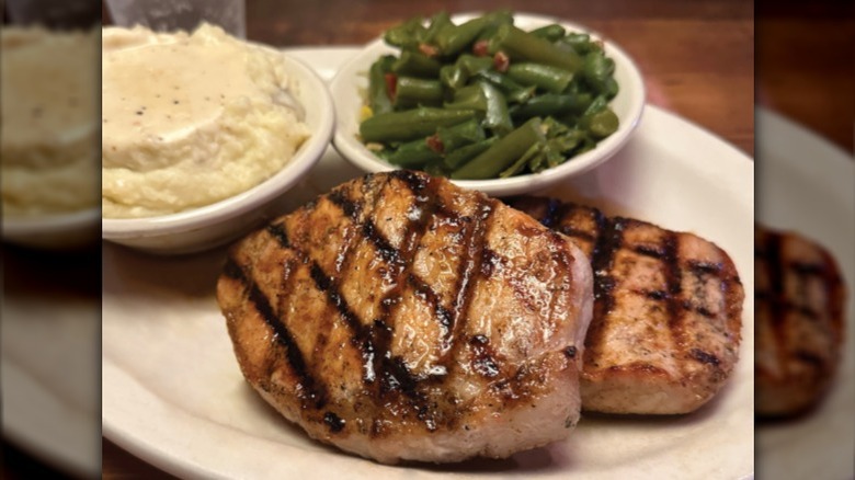 Two grilled pork chops from Texas Roadhouse on white plate