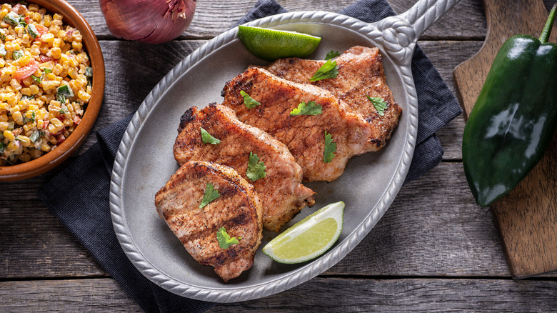 Grilled pork chops on silver plate with limes