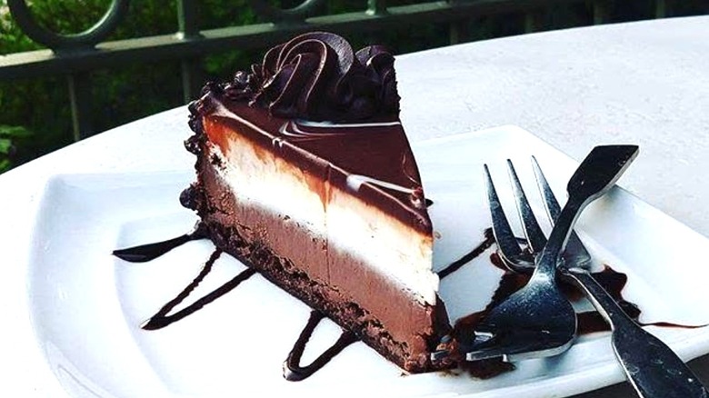 Olive Garden's Black Tie Mousse Cake sits on a white plate with two forks