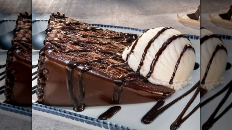 A slice of Red Lobster's Chocolate Wave sits on its side with a scoop of vanilla ice cream on the right
