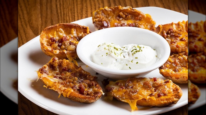 Plate of potato skins with large bowl of sour cream