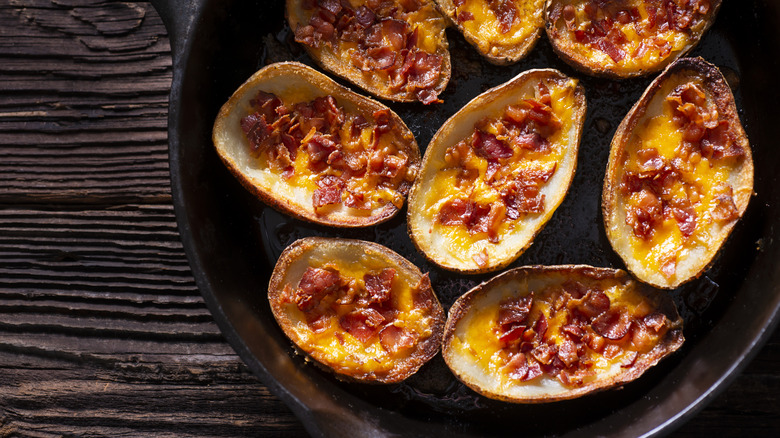 Potato skins in cast iron pan on wooden table
