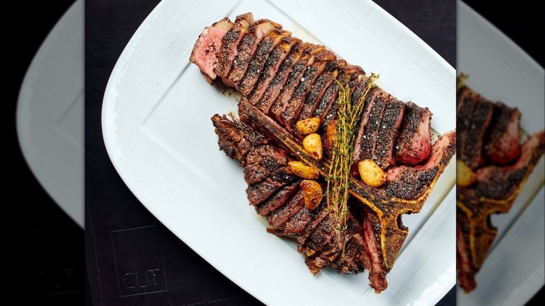 A sliced porterhouse with roasted potatoes