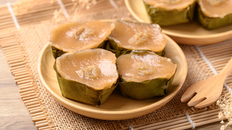 Four sticky rice cakes on a wooden plate