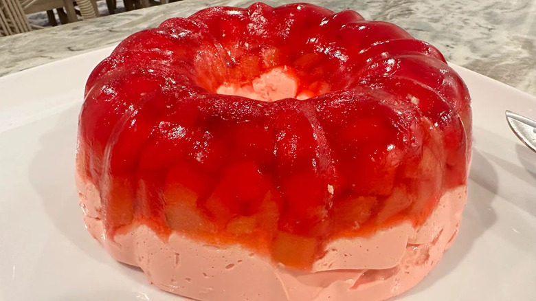 A ring of red Jell-O salad on white plate