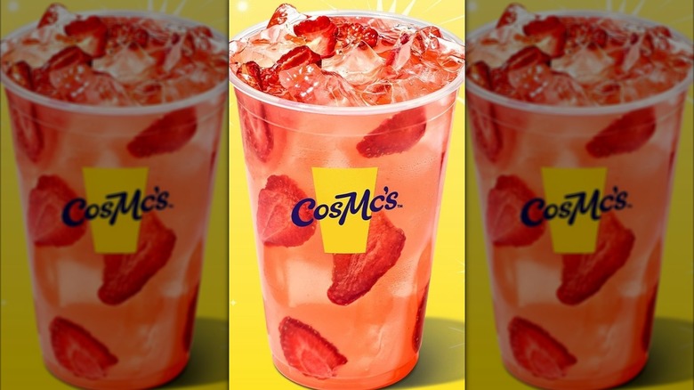 CosMc's island punch lemonade with ice and strawberries on a sparkly yellow background