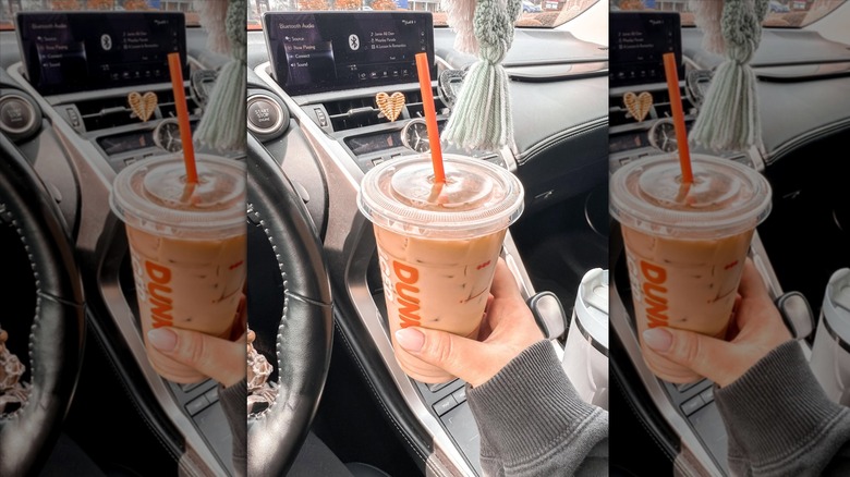 Hand holding Dunkin' iced coffee with toasted almond shot