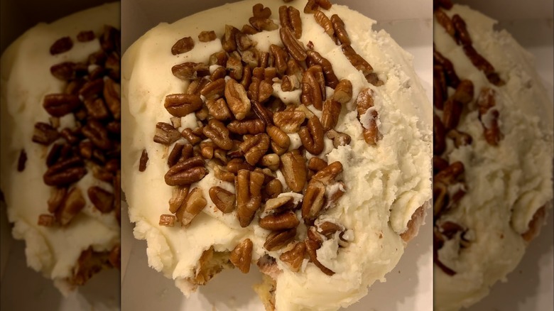 Close up of Buc-ee's frosted cinnamon roll with pecans on top.