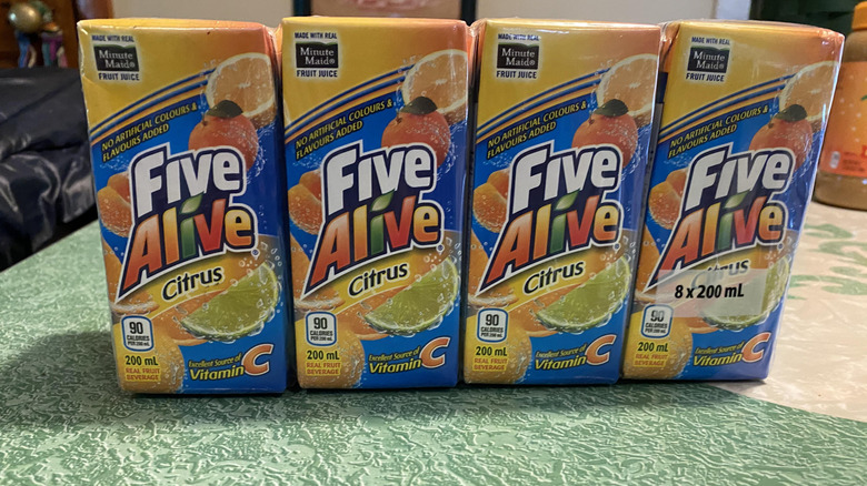 Four boxes of Five Alive in a row on green table