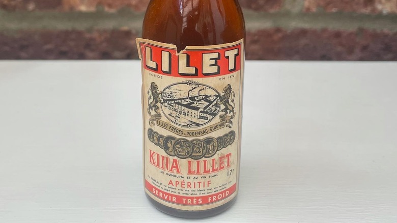 Close up of Kina Lillet label on brown bottle on white surface