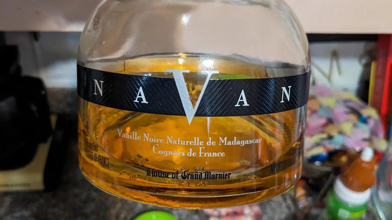 Close up of the bottom of a bottle of Navan with messy worktop in background