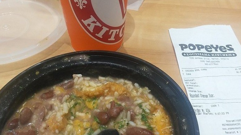 Popeyes Big Easy chicken bowl with drink and receipt on table