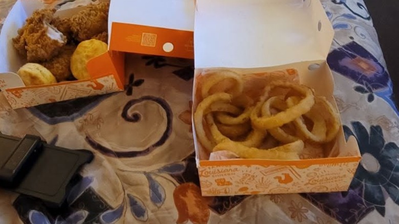 Popeyes onion rings in box on bed