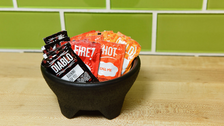 Taco Bell sauce packets in guacomole bowl.