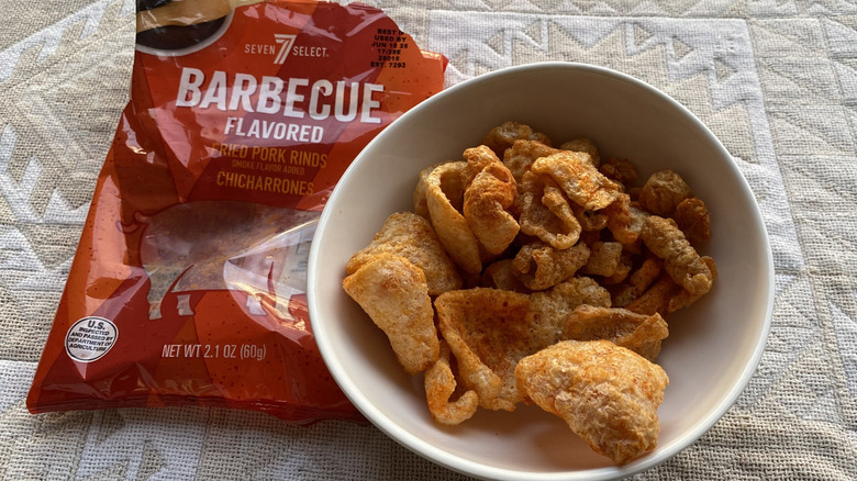Red plastic bag next to bowl of crispy fried pork rinds
