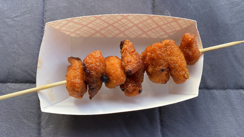 Crispy, lightly charred chicken bites on wooden skewer