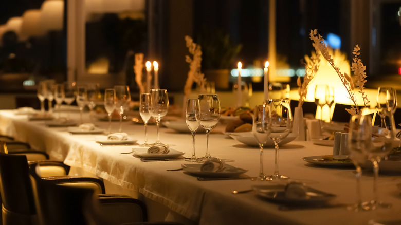 A beautifully arranged dining table is set with glasses and candles, creating a warm atmosphere for guests.