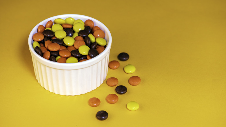 Reese's Pieces in white dish on yellow background