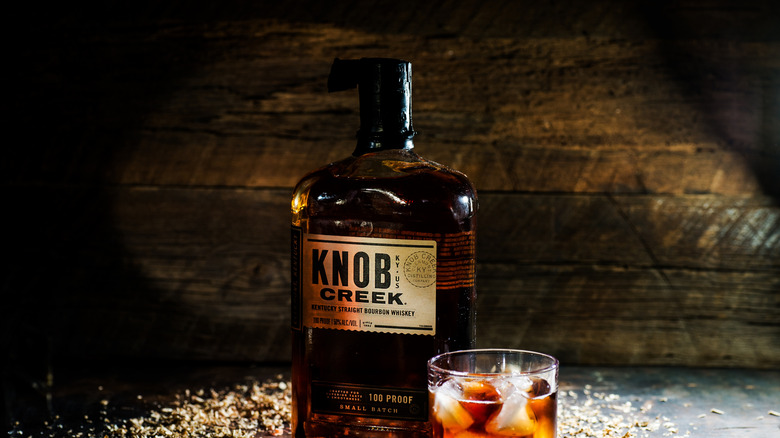 Glasses of whiskey with ice and a bottle of Knob Creek