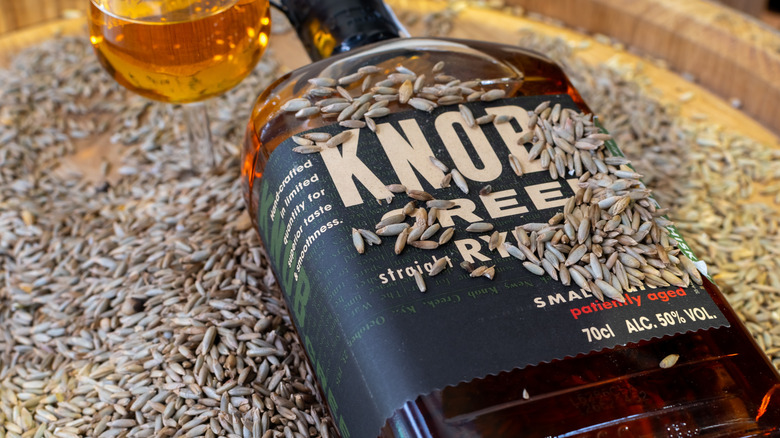 Knob Creek bottle of bourbon on a barrel filled with rye