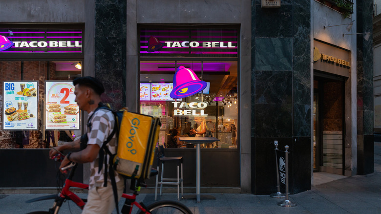 Delivery driver riding past a Taco Bell location