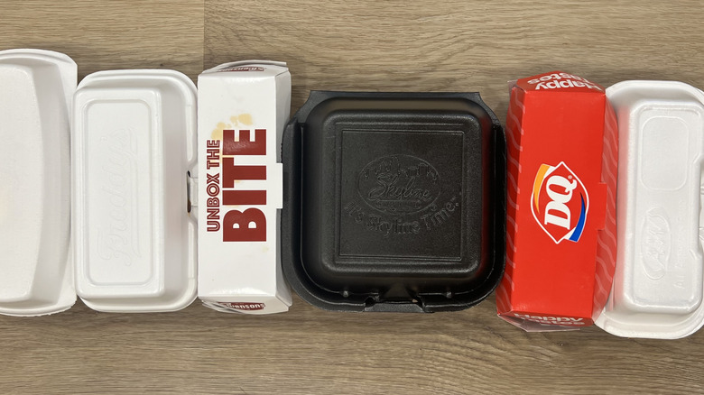 6 different fast food chili cheese dogs in to-go boxes.