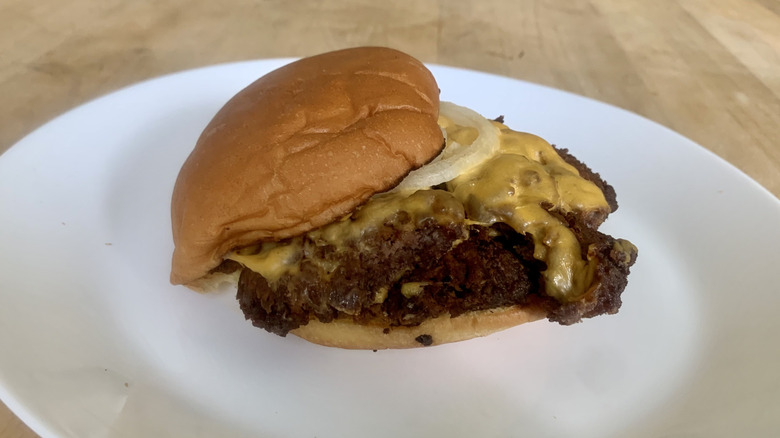Shake Shack double cheeseburger on white plate with wooden background