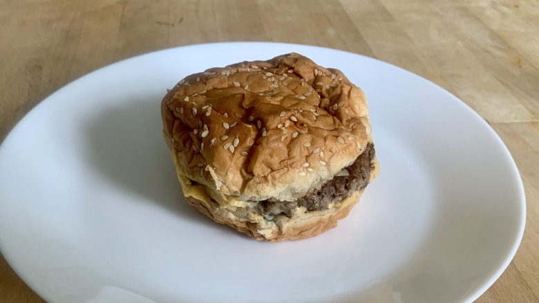 Five Guys double cheeseburger on white plate with wooden background