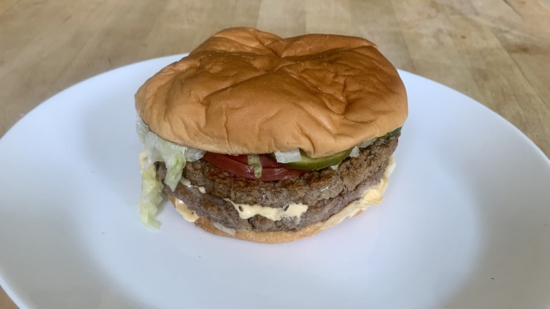 Sonic double cheeseburger on white plate with wooden background