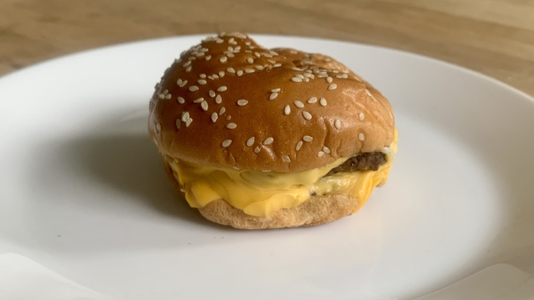 Burger King double cheeseburger on white plate with wooden background