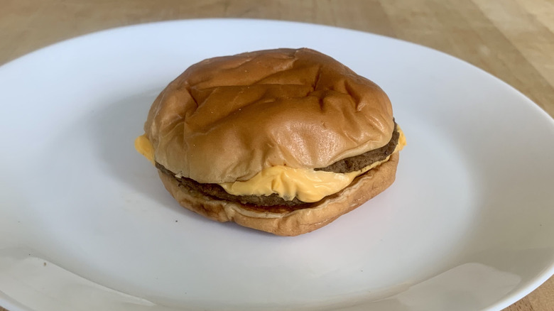 McDonalds double cheeseburger on white plate with wooden background
