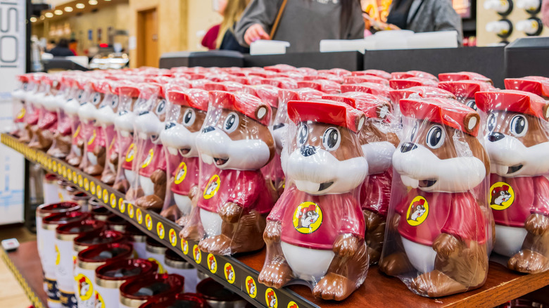 Rows of shrink-wrapped plastic figures of the Buc-ee's beaver mascot on shelves at a store.