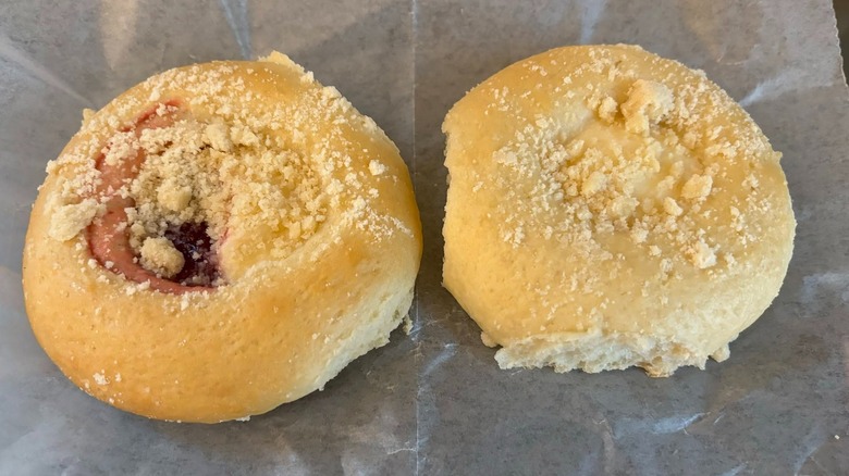 A variety of multi-flavored kolaches in a white pastry box.