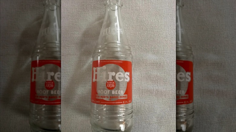 Empty Hires Root Beer bottle on beige background, mirrored image