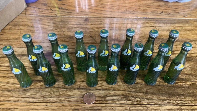 Miniature glass bottles of Teem on wooden table