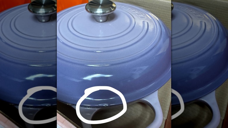 Close up of a blue Le Creuset pot with a chip circled