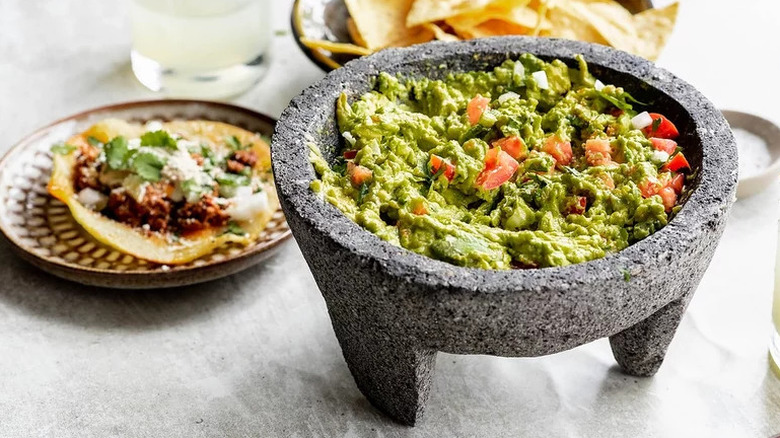 Crave-Worthy Guacamole in molcajete with tortillas on the side