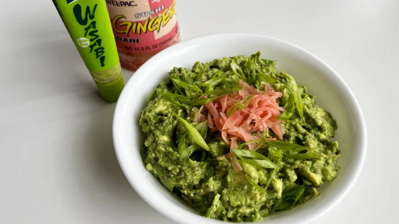 Ginger wasabi guacamole in white bowl with sushi ginger and wasabi on the side