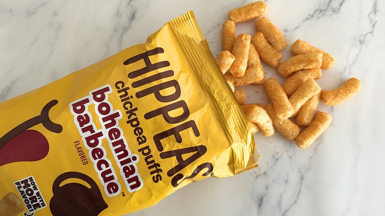 Hippeas spilling out of bag of Bohemian Barbecue Hippeas on white marble surface