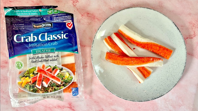 Package of Trans Ocean imitation crab next to imitation crab on white plate