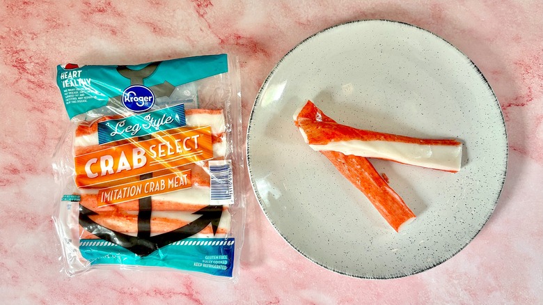 Package of Kroger imitation crab next to imitation crab on white plate