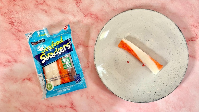 Package of Trans Ocean Seafood Snackers next to imitation crab on white plate